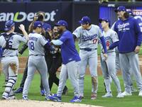 　ブルワーズ戦で完投勝利を挙げ、大谷（17）に迎えられるドジャース・山本（18）＝共同