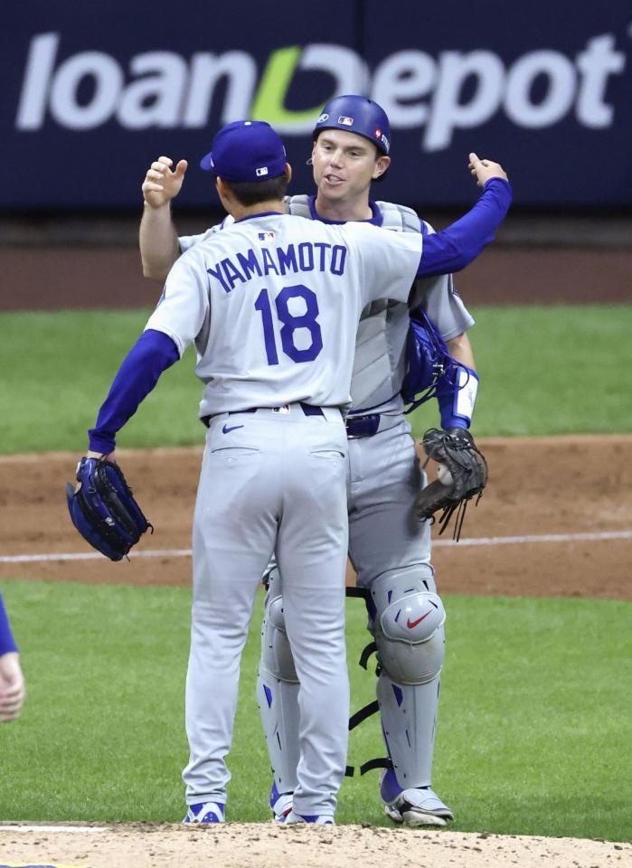 　ブルワーズ戦で完投勝利を挙げ、捕手スミスとハグするドジャース・山本（共同）