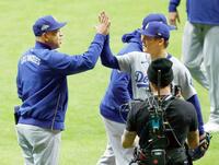 　ロバーツ監督（左）に迎えられる山本（共同）