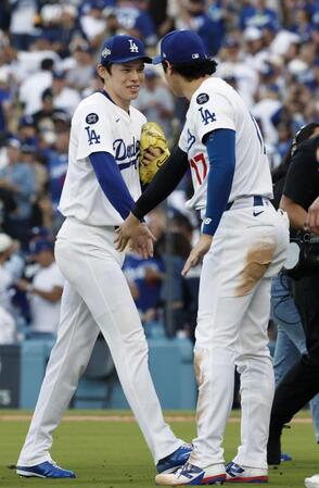 　勝利し、大谷（右）とタッチを交わす佐々木（共同）