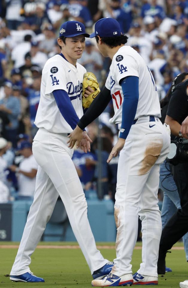 　勝利し、大谷（右）とタッチを交わす佐々木（共同）