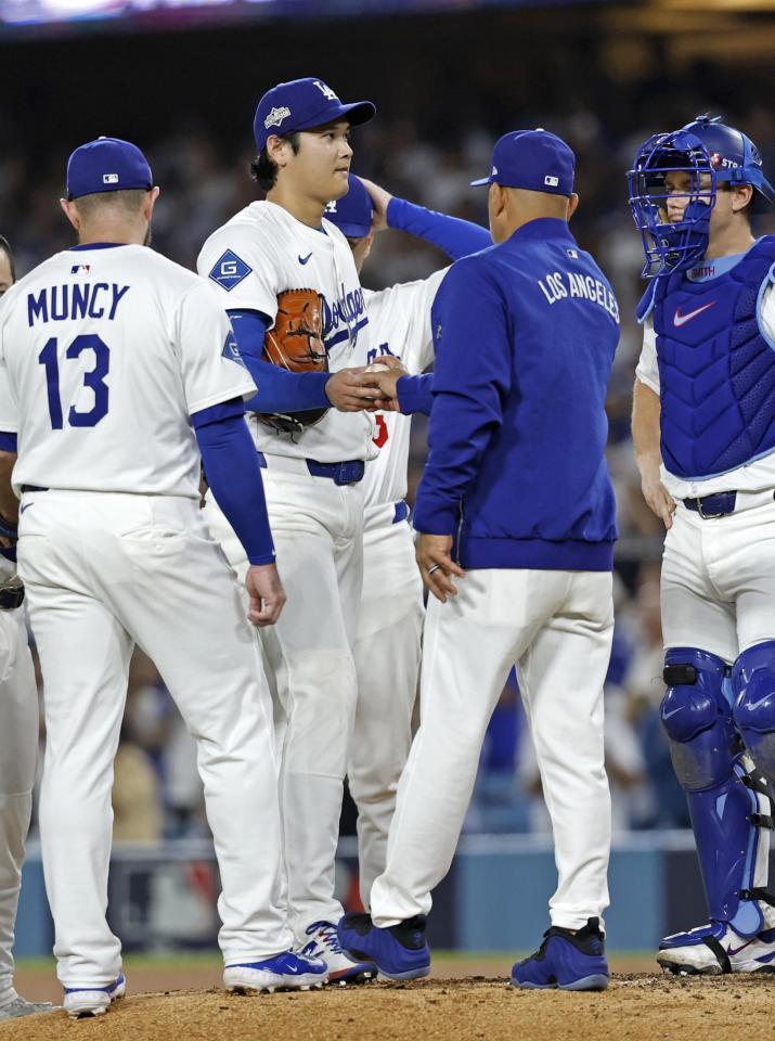 　ブルワーズ戦の７回、ロバーツ監督（右から２人目）にボールを渡し降板するドジャース・大谷（共同）