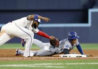　ブルージェイズ戦の９回、けん制で一塁に帰塁するドジャース・大谷。一塁手ゲレロ（共同）