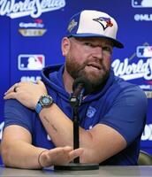 　記者会見で質問に答えるシュナイダー監督（共同）