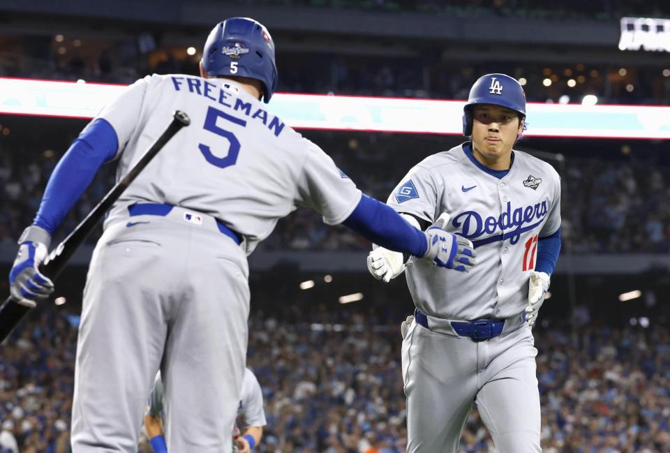 　ブルージェイズ戦の７回、２ランを放ちフリーマン（左）とタッチを交わすドジャース・大谷（共同）