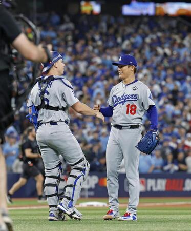 　ブルージェイズ戦で完投勝利を挙げ、捕手スミスと喜ぶドジャース・山本（共同）