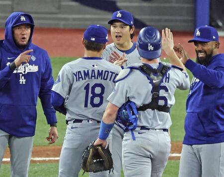 　ブルージェイズ戦で完投勝利を挙げた山本（18）を迎えるドジャース・大谷（共同）
