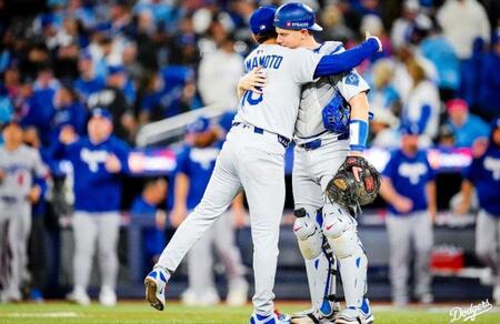 　完投勝利を収めた山本を抱きしめるスミス（ロサンゼルス・ドジャース提供）