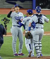 　ブルージェイズ戦で完投勝利を挙げた山本（中央）を迎えるドジャース・大谷（共同）