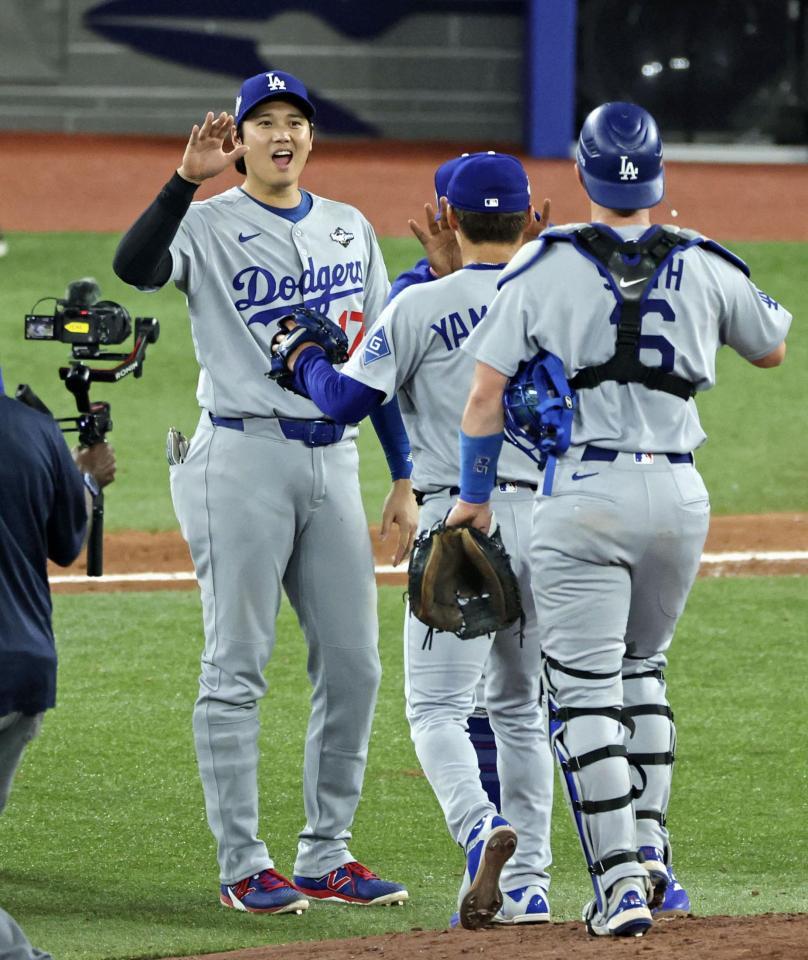 　ブルージェイズ戦で完投勝利を挙げた山本（中央）を迎えるドジャース・大谷（共同）