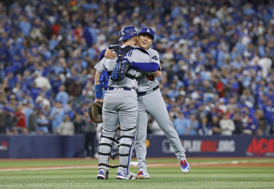 　ブルージェイズ戦で完投勝利を挙げ、捕手スミスと抱き合うドジャース・山本（共同）