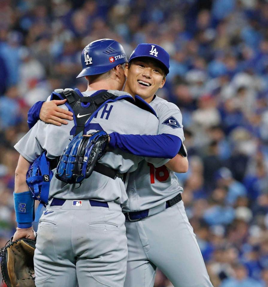 　完投勝利を挙げ、捕手スミスと抱き合う山本（共同）