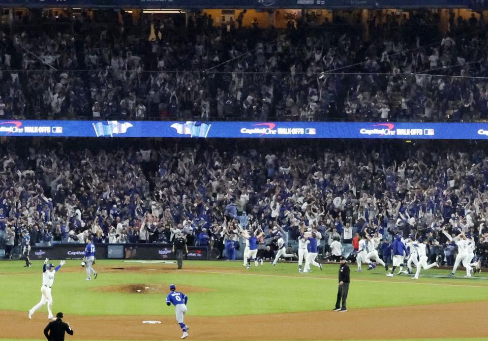 　米大リーグ、ブルージェイズとのワールドシリーズ第３戦の１８回、サヨナラ本塁打を放ったフリーマン（左手前）を迎えるためベンチから駆け出すドジャースの選手たち（共同）