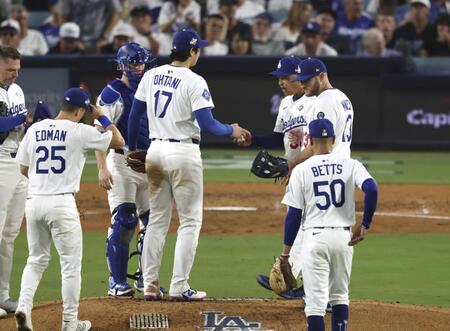 　ブルージェイズ戦の７回途中、降板するドジャース・大谷（17）。右奥はロバーツ監督（共同）