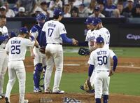 　ブルージェイズ戦の７回途中、降板するドジャース・大谷（17）。右奥はロバーツ監督（共同）
