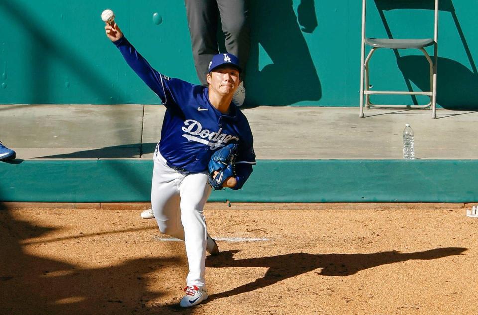 　ブルペンで投球する山本（共同）