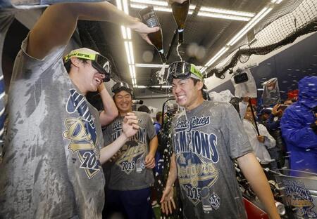 　ワールドシリーズ２連覇を達成し、シャンパンファイトで盛り上がる山本（右）と佐々木（左）＝共同