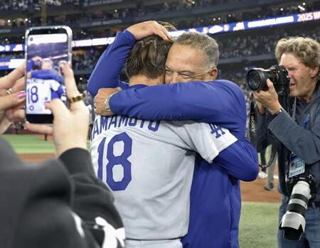 　ワールドシリーズ２連覇を達成し、山本（18）を抱きしめるドジャースのロバーツ監督＝トロント（共同）