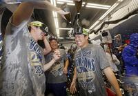 　ワールドシリーズ２連覇を達成し、シャンパンファイトで盛り上がる山本（右）と佐々木（左）＝共同