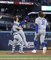 　ブルージェイズとのワールドシリーズ第７戦を制して２連覇を達成し、捕手スミスに抱きかかえられる山本由伸（共同）