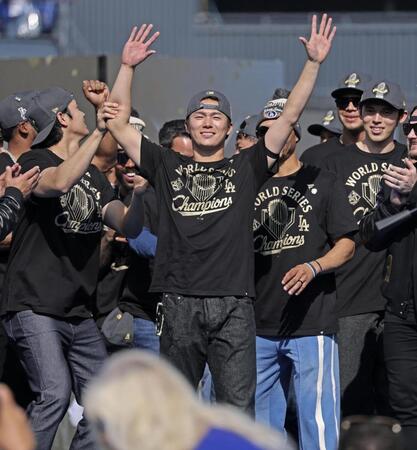 　米大リーグ、ドジャースのワールドシリーズ優勝報告会で、手を上げて歓声に応える山本由伸、その左は大谷翔平、右端は佐々木朗希（共同）