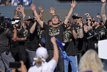 　米大リーグ、ドジャースのワールドシリーズ優勝パレード後に開かれた報告会で歓声に応える、ＷＳ最優秀選手に輝いた山本由伸（中央）。大谷翔平や佐々木朗希も参加し、地元のファンから熱狂的な歓迎を受けた（共同）