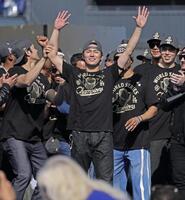 　米大リーグ、ドジャースのワールドシリーズ優勝報告会で、手を上げて歓声に応える山本由伸、その左は大谷翔平、右端は佐々木朗希（共同）