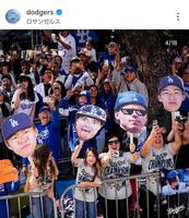 　優勝パレードで山本由伸の顔写真（左）を掲げるファン。ドジャースの公式インスタグラム＠ｄｏｄｇｅｒｓより