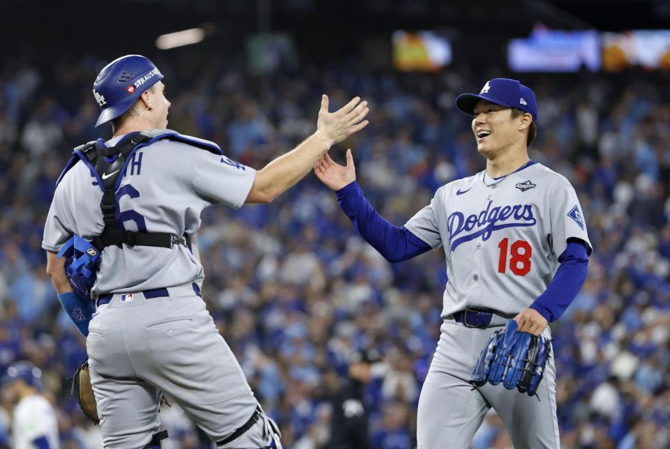 　ブルージェイズ戦の９回、満塁のピンチを切り抜け、捕手スミスと喜ぶドジャース・山本＝トロント（共同）