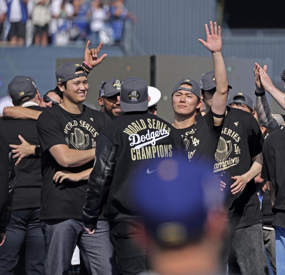 　米大リーグ、ドジャースのワールドシリーズ優勝報告会で、手を上げて歓声に応える山本由伸と笑顔の大谷翔平（共同）