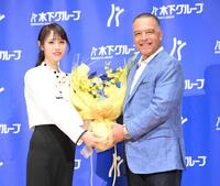 　「木下グループＣＭ第二弾制作発表会」でＷＳ連覇を祝う花束を受け取るドジャースのロバーツ監督（右）＝撮影・伊藤笙子