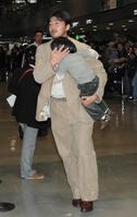 　子供を抱きかかえ帰国したドジャース・石井＝成田空港