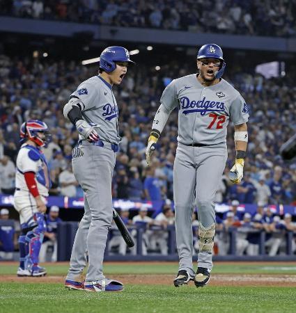 　ワールドシリーズ第７戦、ブルージェイズ戦の９回、同点ソロを放ったロハス（右）を迎えるドジャース・大谷＝１１月、トロント