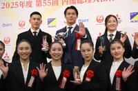 　受賞者と並んで手を振る山本（中央）＝撮影・西岡正