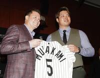 　ホワイトソックスの入団記者会見でユニホームを手にする村上宗隆。左はゲッツ・ゼネラルマネジャー（共同）