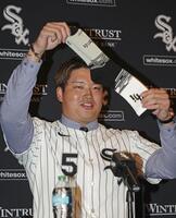 　米大リーグ、ホワイトソックスの入団記者会見で靴下を掲げる村上宗隆（共同）