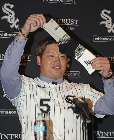 　ホワイトソックスの入団記者会見で靴下を掲げる村上宗隆内野手＝２２日、シカゴ（共同）