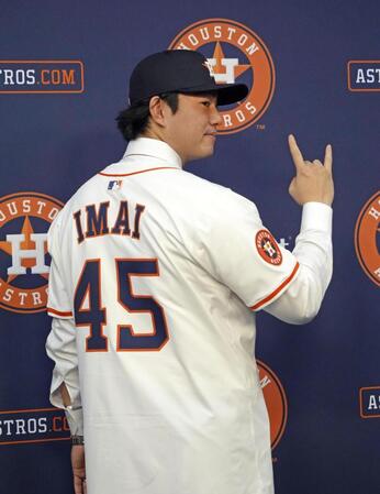 　米大リーグ、アストロズの入団記者会見で背番号「45」のユニホームに袖を通し、ポーズをとる今井達也投手（共同）