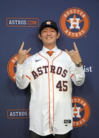 　米大リーグ、アストロズの入団記者会見でユニホームに袖を通し、ポーズをとる今井達也投手（共同）