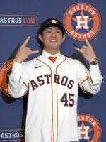 　米大リーグ、アストロズの入団記者会見でユニホームに袖を通し、ポーズをとる今井達也投手（共同）