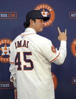 　米大リーグ、アストロズの入団記者会見で背番号「45」のユニホームに袖を通し、ポーズをとる今井達也投手（共同）