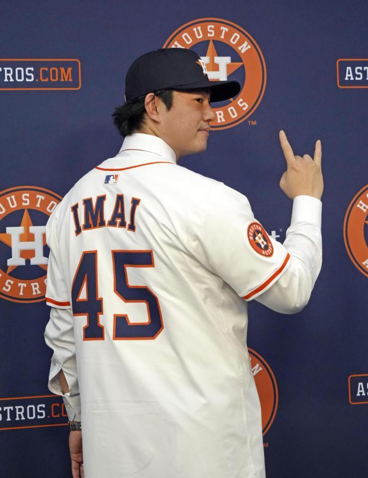　米大リーグ、アストロズの入団記者会見で背番号「45」のユニホームに袖を通し、ポーズをとる今井達也投手（共同）