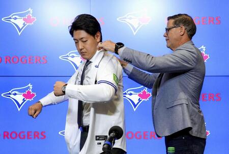 　米大リーグ、ブルージェイズの入団記者会見でユニホームを着る岡本和真（共同）