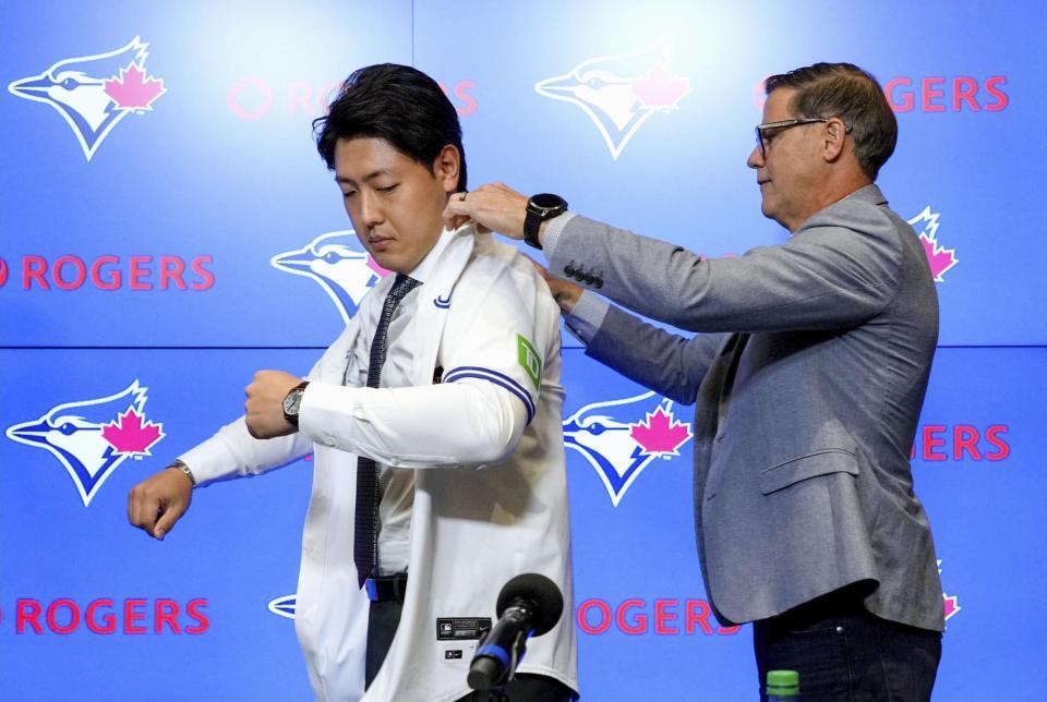 　米大リーグ、ブルージェイズの入団記者会見でユニホームを着る岡本和真（共同）