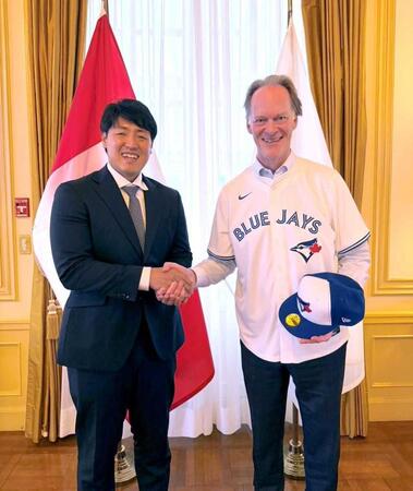　笑顔で握手を交わす岡本（左）とイアン・マッケイ駐日カナダ大使