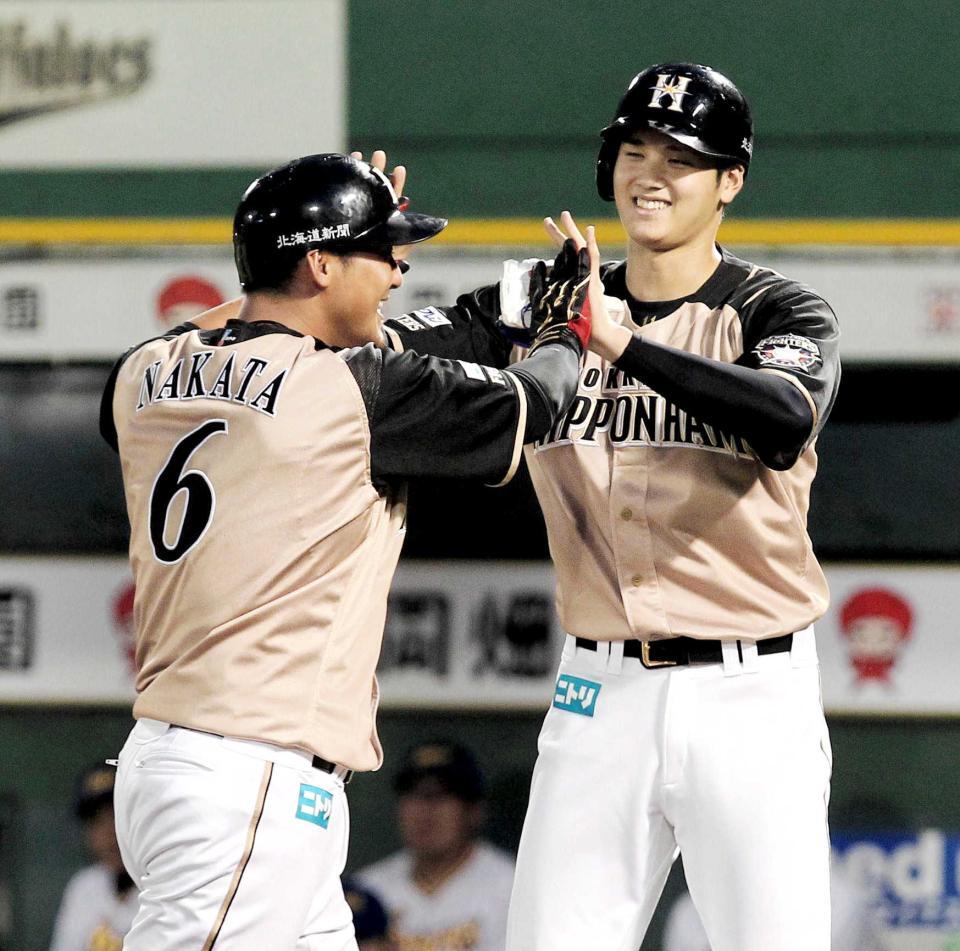 右越え３点本塁打を放ち、走者大谷翔平に迎えられる中田翔＝１６年９月