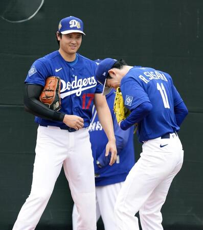 　キャンプ初日、ブルペンで投球練習を終えた佐々木朗希（右）と話す米大リーグ、ドジャースの大谷翔平＝13日、グレンデール（共同）