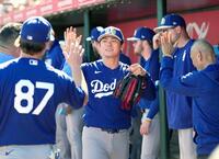 ２回途中に降板し、ベンチで迎えられる山本（共同）