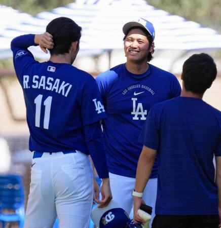 　チームに合流し、佐々木（左）と笑顔で話す大谷（共同）