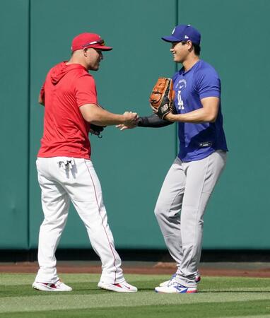 　試合前の練習で、エンゼルスのトラウト（左）と握手を交わすドジャース・大谷＝アナハイム（共同）